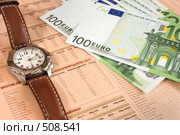 Часы и купюры в сто евро, лежащие поверх биржевых котировок (2008 год). Редакционное фото, фотограф Дмитрий Яковлев / Фотобанк Лори
