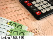 Калькулятор и купюры в сто евро, лежащие поверх биржевых котировок (2008 год). Редакционное фото, фотограф Дмитрий Яковлев / Фотобанк Лори