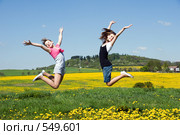 Радостные девочки прыгают в цветущем поле. Стоковое фото, фотограф Ирина Игумнова / Фотобанк Лори