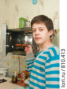 Юноша собирается разогреть еду в микроволновке (2009 год). Редакционное фото, фотограф Ирина Солошенко / Фотобанк Лори