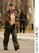 Старый фотограф идущий по улице (2009 год). Редакционное фото, фотограф Михаил Митин / Фотобанк Лори