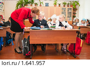 Учительница помогает первоклассникам на уроке (2009 год). Редакционное фото, фотограф Кекяляйнен Андрей / Фотобанк Лори