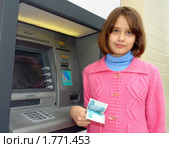 Девочка с полученными деньгами возле банкомата (2010 год). Редакционное фото, фотограф Александр Тараканов / Фотобанк Лори