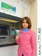 Девочка с полученными деньгами возле банкомата (2010 год). Редакционное фото, фотограф Александр Тараканов / Фотобанк Лори