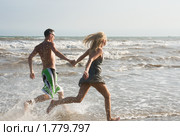Счастливая молодая пара бежит по берегу моря. Стоковое фото, фотограф Ирина Игумнова / Фотобанк Лори