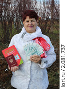 Женщина держит в руках атлас мира, заграничный паспорт и деньги. Стоковое фото, фотограф Ольга Линевская / Фотобанк Лори
