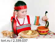 Девочка в русском народном костюме за столом с блинами и красной икрой . Масленица. Стоковое фото, фотограф RedTC / Фотобанк Лори