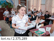 Ученица отвечает урок, а другие ученики тянут руки и желают добавить (2011 год). Редакционное фото, фотограф Федор Королевский / Фотобанк Лори
