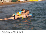 Мужчина с дочкой катаются на надувном плотике в море (2011 год). Редакционное фото, фотограф Юлия Машкова / Фотобанк Лори