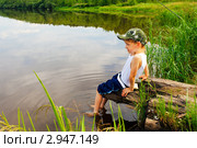 Мальчик сидит на берегу реки (2011 год). Редакционное фото, фотограф Сергей Гусев / Фотобанк Лори