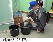 Рабочий готовит клей для кафельной плитки (2011 год). Редакционное фото, фотограф Владимир Горощенко / Фотобанк Лори