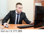 Мужчина за столом в офисе работает на компьютере. Стоковое фото, фотограф Кекяляйнен Андрей / Фотобанк Лори