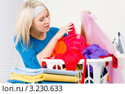 Домохозяйка разбирает постиранное белье. Стоковое фото, фотограф CandyBox Images / Фотобанк Лори