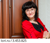 Портрет симпатичной женщины  в очках в красном платье возле шкафа. Стоковое фото, фотограф Игорь Низов / Фотобанк Лори