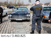 Полицейский фотографирует автомобиль марки "Кадиллак" на ралли классических автомобилей клуба РККА на Поклонной горе, Москва, Россия (2012 год). Редакционное фото, фотограф Николай Винокуров / Фотобанк Лори