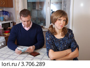 Муж и жена пересчитывают деньги скудного семейного бюджета, сидя на кухне. Стоковое фото, фотограф Яков Филимонов / Фотобанк Лори