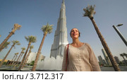 Женщина стоит перед фонтанами у отеля Бурдж Дубай Лэйк  в Дубае, ОАЭ (2010 год). Редакционное видео, видеограф Losevsky Pavel / Фотобанк Лори