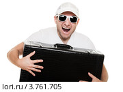Радостный  молодой мужчина в темных очках и бейсболке с большим чемоданом в руках. Стоковое фото, фотограф Илья Андриянов / Фотобанк Лори