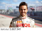 Гонщик Сергей Афанасьев, член команды Leipert Motorsport в питлейне готовится к участию в Чемпионате Европы FIA GT3 на треке Moscow Raceway в Подмосковье (2012 год). Редакционное фото, фотограф Николай Винокуров / Фотобанк Лори