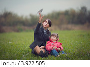 Мама с дочкой запускают бумажный самолетик на лугу. Стоковое фото, фотограф Наталья Чуб / Фотобанк Лори