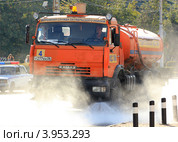 Поливальная машина поливает проезжую дорогу (2012 год). Редакционное фото, фотограф Rekacy / Фотобанк Лори