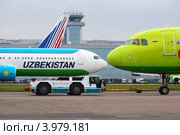 Самолеты авиакомпаний Uzbekistan Airways (Узбекские авиалинии) и S7 Airlines на фоне фасада  аэропорта Домодедово города Москвы (2012 год). Редакционное фото, фотограф Николай Винокуров / Фотобанк Лори