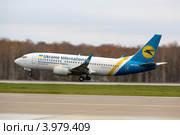 Самолет Boeing 737 авиакомпании "Международные авиалинии Украины" садится на взлетно-посадочную полосу аэропорта Домодедово города Москвы (2012 год). Редакционное фото, фотограф Николай Винокуров / Фотобанк Лори
