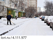 Дворник чистит тротуар от снега во дворе многоэтажного дома (2011 год). Редакционное фото, фотограф Анна Мартынова / Фотобанк Лори