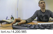 Мужчина за столом в офисе работает на компьютере. Таймлапс. Стоковое видео, видеограф Кекяляйнен Андрей / Фотобанк Лори