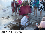 Молодая женщина заходит в прорубь для погружения в воду (2013 год). Редакционное фото, фотограф Кекяляйнен Андрей / Фотобанк Лори