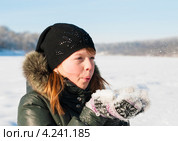 Девочка сдувает снег с варежек на прогулке. Стоковое фото, фотограф Игорь Низов / Фотобанк Лори