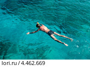 Молодой человек с маской и трубкой лежит на поверхности моря. Стоковое фото, фотограф Кекяляйнен Андрей / Фотобанк Лори