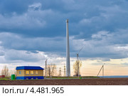 Ветроэлектростанция возле дома в поле. Wind power plant near the house in the field. Стоковое фото, фотограф Олег Голиков / Фотобанк Лори