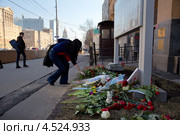 Женщина приносит цветы к посольству США в Москве, скорбя по жертвам взрывов на 117-м Бостонском марафоне (2013 год). Редакционное фото, фотограф Николай Винокуров / Фотобанк Лори