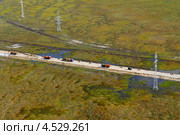 Усть-Тегусское нефтяное месторождение. Уватский район, Тюменская область. Дорожное покрытие, подъездные дороги. Вид с вертолета. Болото, топь, трясина, техника. Россия, Сибирь, Тюмень. Дорожная одежда, земляное полотно, строительная техника. 2011 год. Стоковое фото, фотограф Александр Циликин / Фотобанк Лори