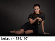 Женщина с кинжалом сидит на тёмном фоне. Стоковое фото, фотограф Ivan Ryzhenko / Фотобанк Лори