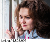 Симпатичная девушка задумчиво смотрит в окно. Стоковое фото, фотограф Игорь Низов / Фотобанк Лори