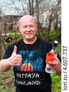 Счастливый мужчина с бутылкой водки и стаканом на улице (2013 год). Редакционное фото, фотограф Игорь Низов / Фотобанк Лори