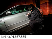 Автомобильный вор вскрывает дверь у машины. Стоковое фото, фотограф Андрей Армягов / Фотобанк Лори