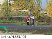 Физруки натягивают волейбольную сетку. Средняя школа (2012 год). Редакционное фото, фотограф Анатолий Матвейчук / Фотобанк Лори