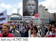 Женщина с портретом Михаила Ходорковского участвует в "Марше против палачей" напротив кинотеатра Ударник в центре города Москвы, Россия (2013 год). Редакционное фото, фотограф Николай Винокуров / Фотобанк Лори