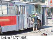 Художник граффити расписывает троллейбус (2013 год). Редакционное фото, фотограф Алексей Букреев / Фотобанк Лори