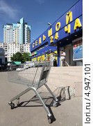 Тележка для продуктов на фоне универмага (2013 год). Редакционное фото, фотограф Андрей Гривцов / Фотобанк Лори