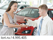 Продавец вручает женщине ключи от нового автомобиля. Стоковое фото, фотограф Дмитрий Калиновский / Фотобанк Лори