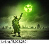 Выживший в ядерной войне показывает рукой на знак радиации. Стоковое фото, фотограф Sergey Nivens / Фотобанк Лори