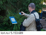Турист сканирует QR-код в Нижнем парке Петергофа (2013 год). Редакционное фото, фотограф Геннадий Соловьев / Фотобанк Лори