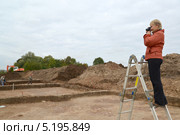 Женщина фотографирует археологические раскопки, стоя на лестнице. Стоковое фото, фотограф Ирина Борсученко / Фотобанк Лори