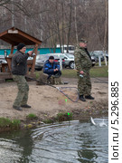 Мужчина вываживает пойманную форель на берег (2013 год). Редакционное фото, фотограф Михаил Иванов / Фотобанк Лори