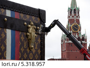 Демонтаж скандальной рекламной конструкции в виде чемодана Louis Vuitton на Красной площади на фоне Спасской башни Московского кремля (2013 год). Редакционное фото, фотограф Николай Винокуров / Фотобанк Лори