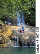 Туристы на фоне водопада Сайок Ной (Sai Yok Waterfall). Национальный парк Сай Йок, Канчанабури, Королевство Таиланд (2013 год). Редакционное фото, фотограф Григорий Писоцкий / Фотобанк Лори